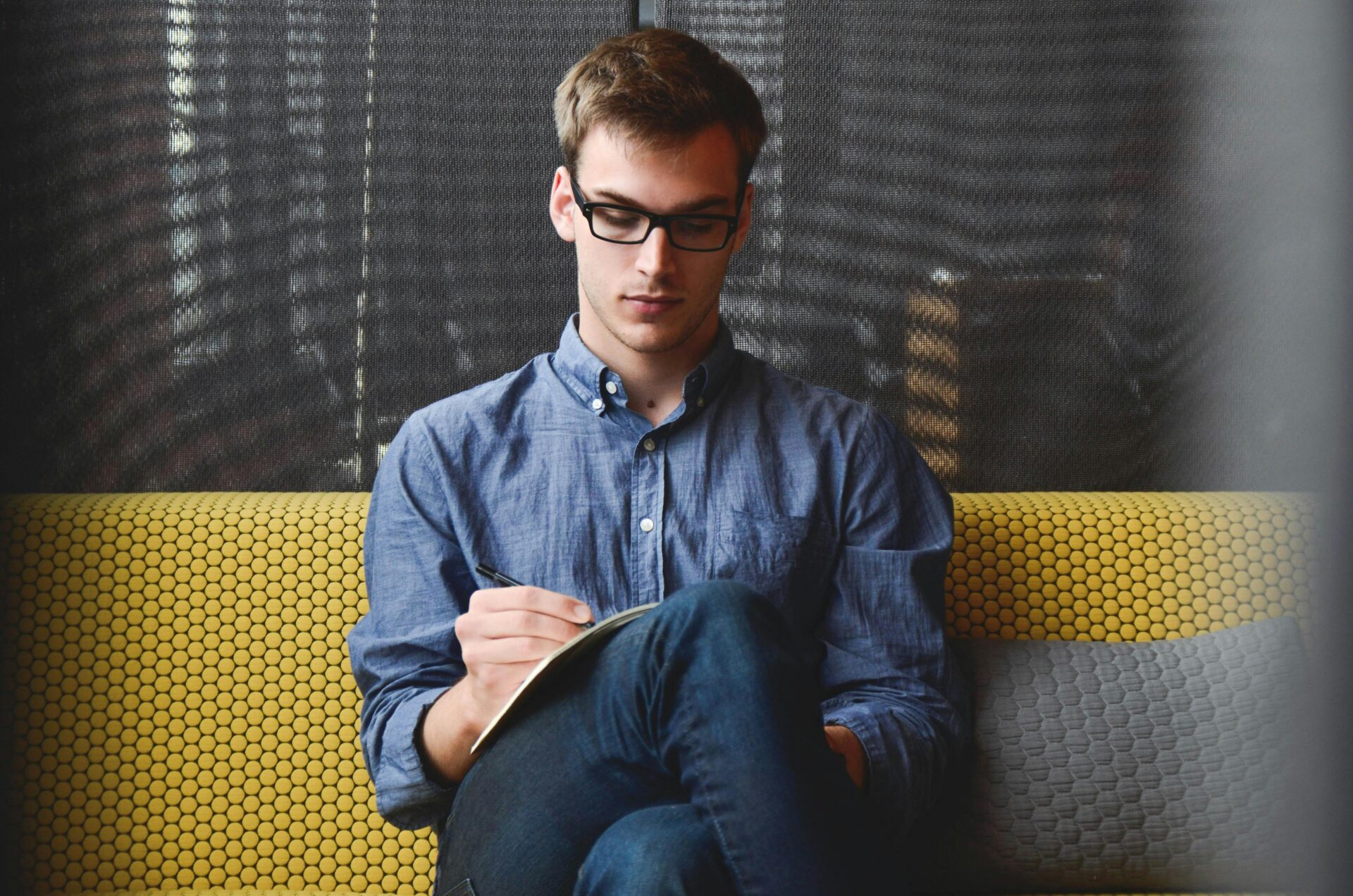 Blog | iGlobalWeb | Web Design SEO eCommerce Marketing Printing Company | entrepreneur startup start up man 39866 39866 scaled A young man in glasses writes in a notebook while sitting on a stylish couch indoors.