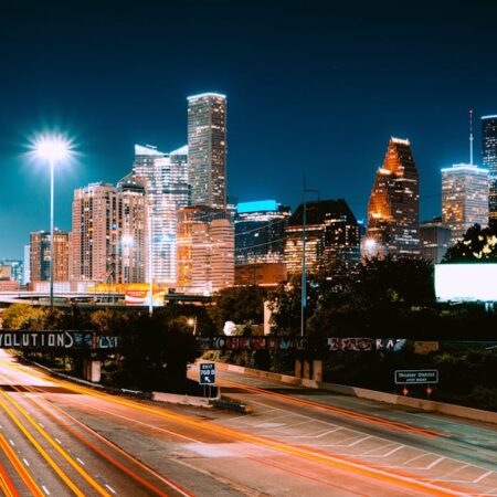 Captivating view of Houston's skyline at night with light trails and illuminated buildings.