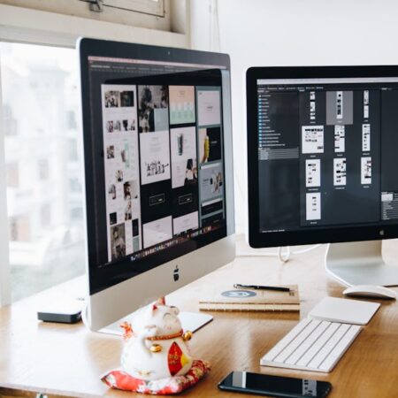 A sleek modern office setup featuring dual monitors, Apple devices, and creative decor in an indoor workspace.